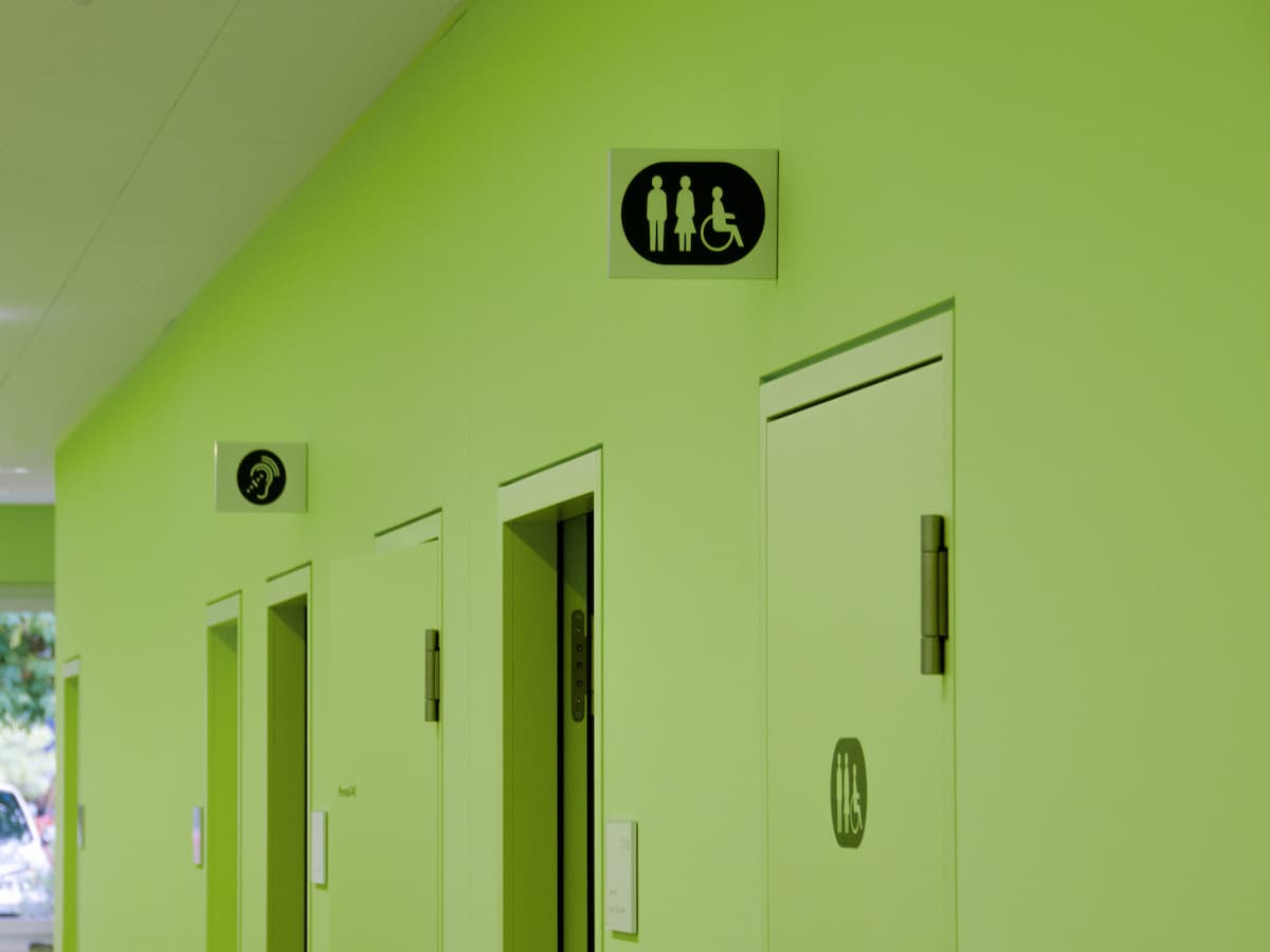 Grüne Wand mit WC-Piktogrammen und Lift im Kastanienpark Oberdiessbach