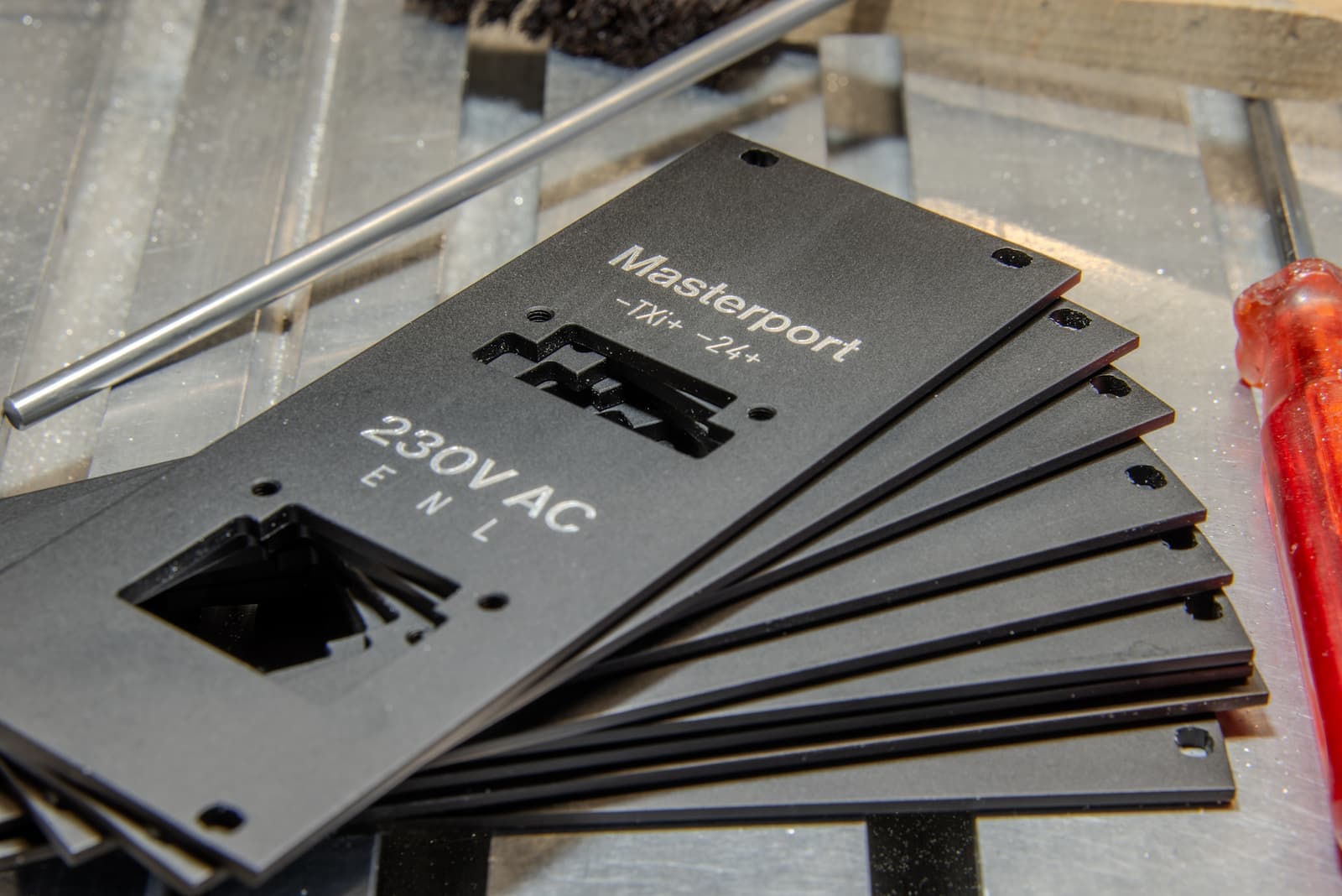 Gestapelte Frontplatten «Masterport 230V AC» aus schwarz eloxiertem Aluminium