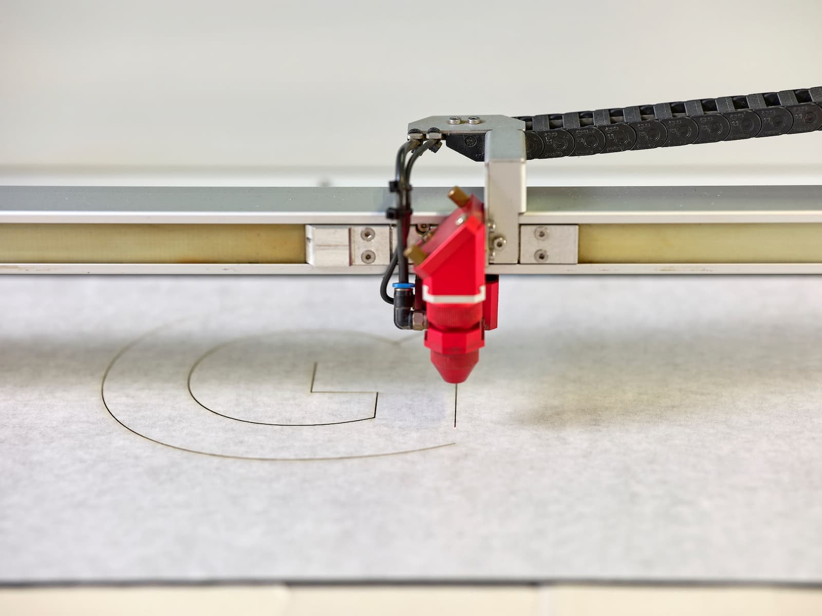 CO₂-Laser schneidet den Buchstaben «G» für die Gebäudeschrift aus