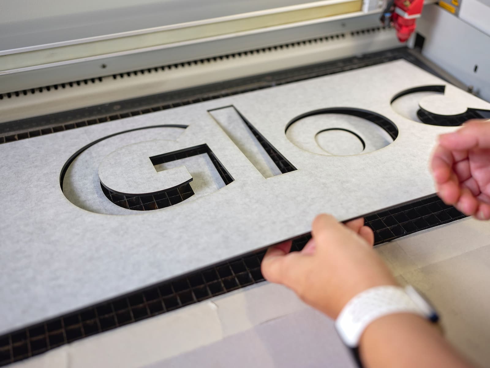 Ausgefräste Buchstaben der Gebäudeschrift werden aus der Platte gelöst
