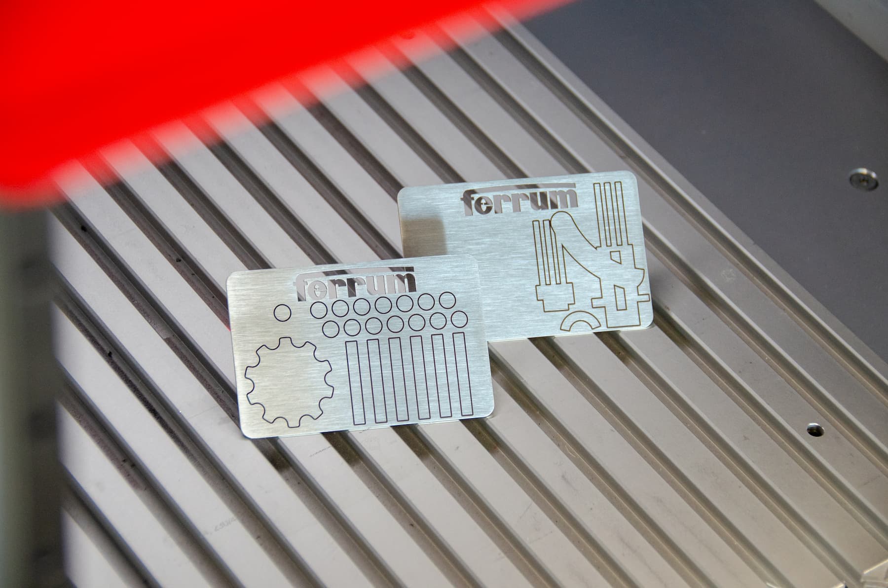 Lasermarkierte Typenschilder aus Chromstahl für Ferrum auf dem Arbeitstisch des Faserlasers